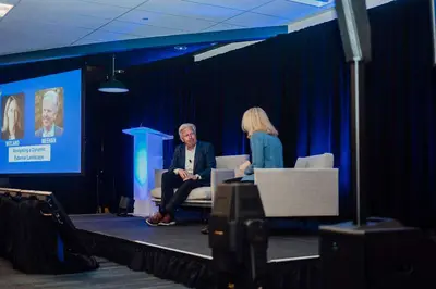 Corporate event photography — panel on a lit conference stage