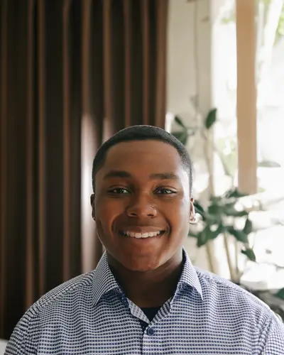 Myles Braxton smiling, in a blue patterned shirt